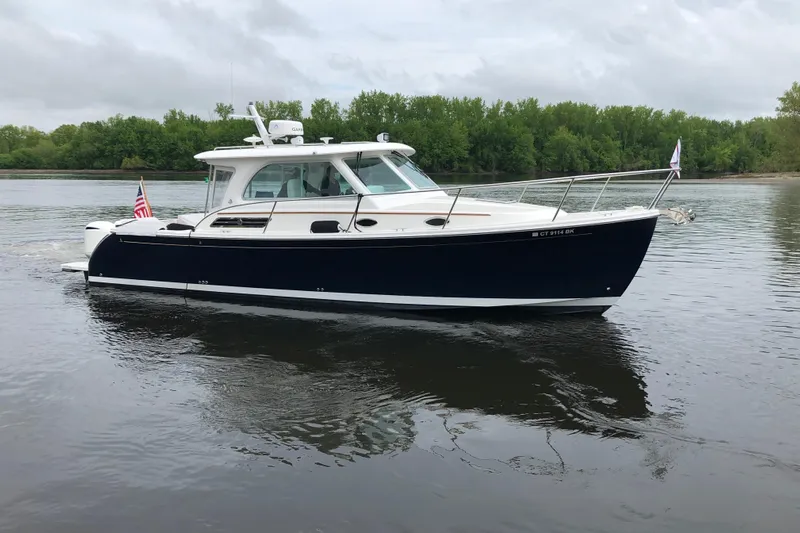Laure Marie Yacht Photos Pics 2020 Back Cove 34O boat cruising on a calm river with lush green trees.