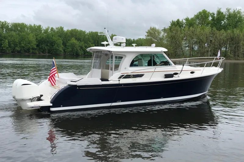 Laure Marie Yacht Photos Pics 2020 Back Cove 34O boat on calm water, featuring sleek design and American flag.