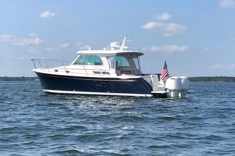Laure Marie Yacht Photos Pics 2020 Back Cove 34O boat on water, clear sky, American flag displayed.