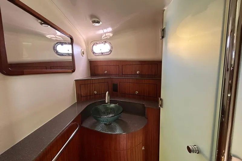  Yacht Photos Pics Luxurious bathroom in 2014 Pursuit OS 385 Offshore boat with modern fixtures and wood cabinetry.