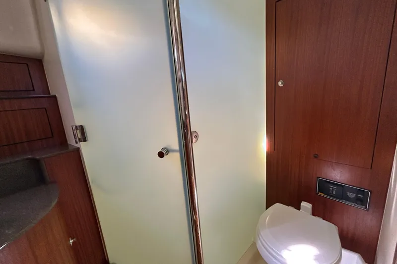  Yacht Photos Pics 2014 Pursuit OS 385 Offshore yacht bathroom with wooden cabinetry and modern fixtures.