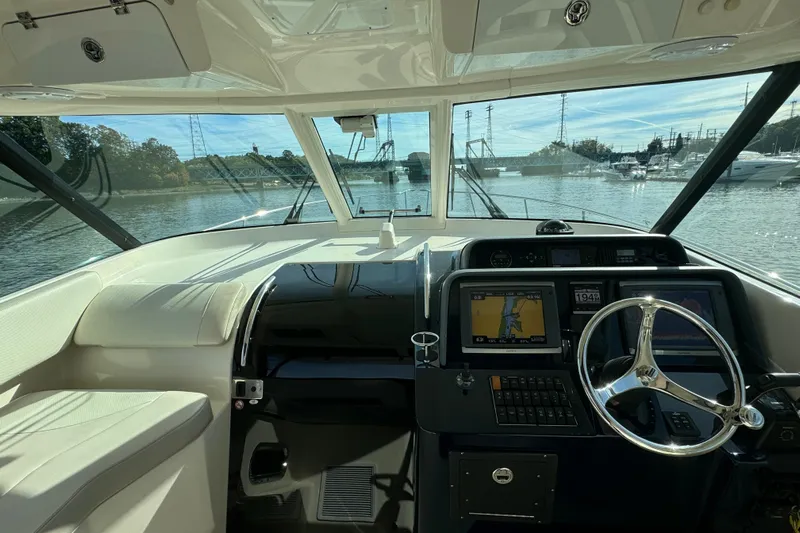  Yacht Photos Pics 2014 Pursuit OS 385 Offshore helm with navigation screens and steering wheel, docked in marina.