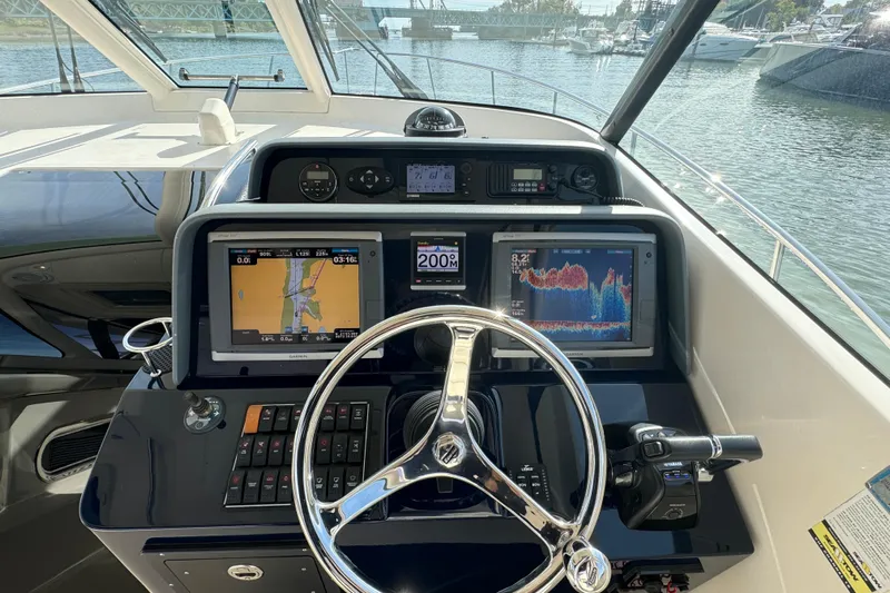  Yacht Photos Pics Helm of 2014 Pursuit OS 385 Offshore boat with navigation screens and steering wheel.