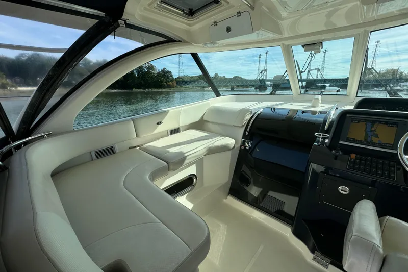  Yacht Photos Pics 2014 Pursuit OS 385 Offshore boat interior with navigation system and seating, overlooking waterway.