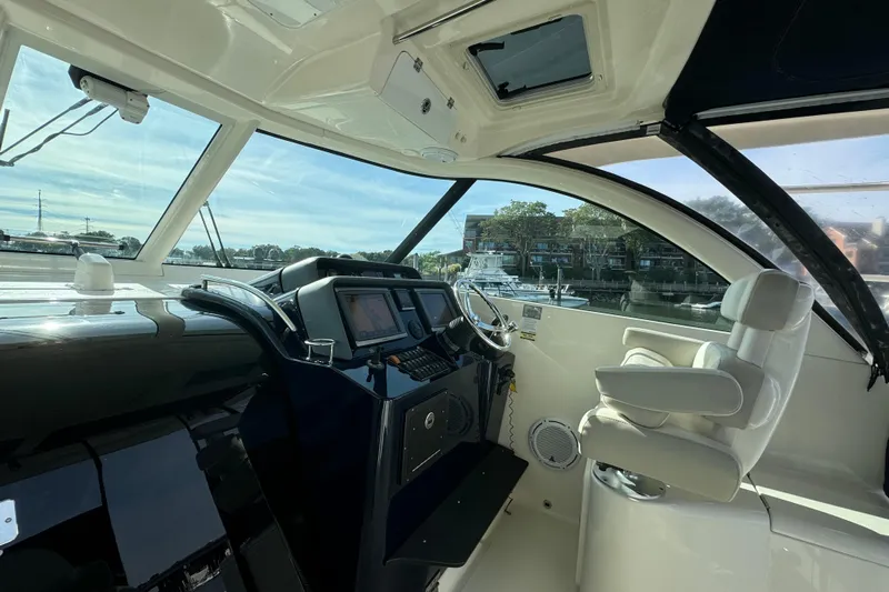  Yacht Photos Pics 2014 Pursuit OS 385 Offshore boat cockpit with modern navigation equipment and comfortable seating.