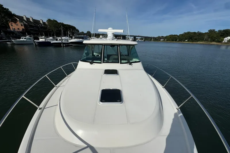  Yacht Photos Pics 2014 Pursuit OS 385 Offshore boat on calm water, docked near marina.