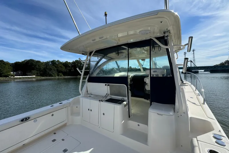  Yacht Photos Pics 2014 Pursuit OS 385 Offshore boat docked on a calm river under a clear blue sky.