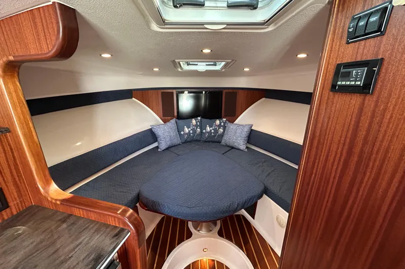  Yacht Photos Pics 2014 Pursuit OS 385 Offshore cabin interior with elegant wood finish and cozy seating.