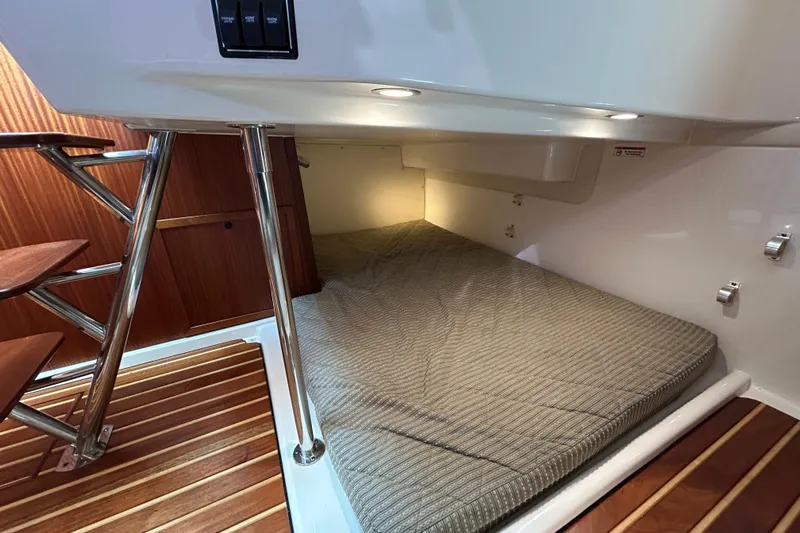  Yacht Photos Pics 2014 Pursuit OS 385 Offshore cabin interior with bed and wooden flooring.