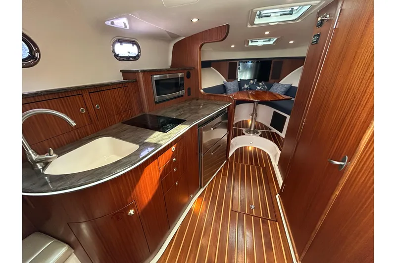  Yacht Photos Pics Luxurious interior of 2014 Pursuit OS 385 Offshore yacht with wood finishes and modern amenities.