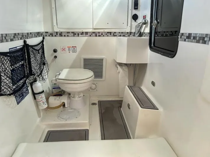  Yacht Photos Pics 2023 AMP Arth 333 boat interior bathroom with toilet, sink, and storage compartments.