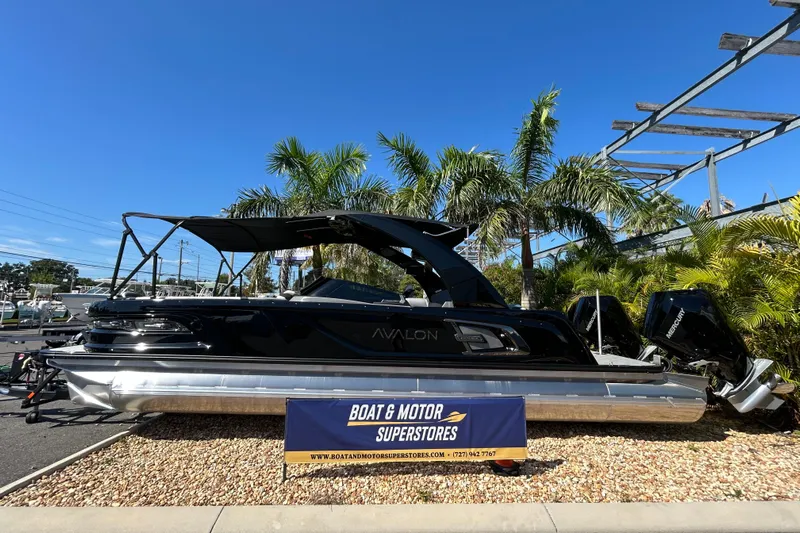  Yacht Photos Pics 2026 Avalon Excalibur 27-Foot boat displayed at dealership with palm trees in background.