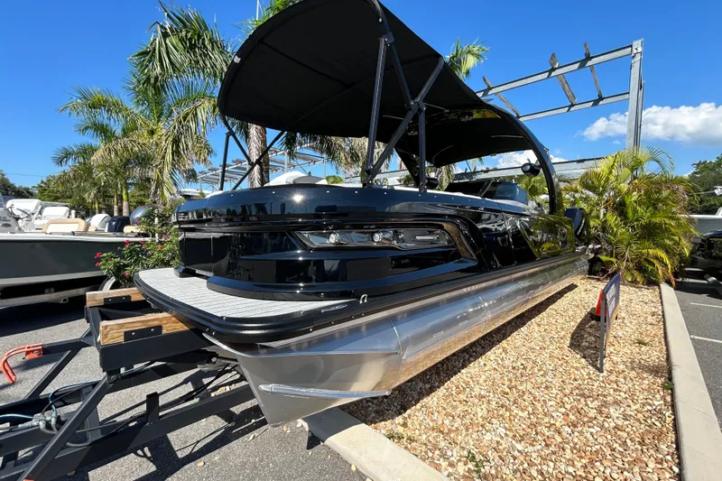  Yacht Photos Pics 2026 Avalon Excalibur 27-foot boat displayed outdoors with palm trees.