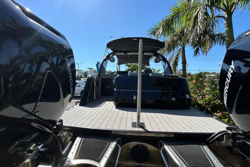  Yacht Photos Pics 2026 Avalon Excalibur 27-Foot boat with Mercury engines, docked under palm trees.