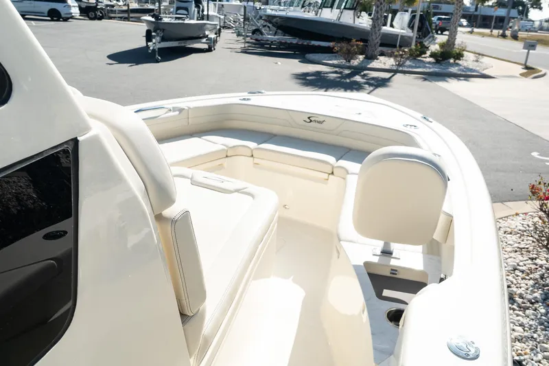  Yacht Photos Pics 2025 Scout 261 XSS boat interior with seating and console in a marina setting.