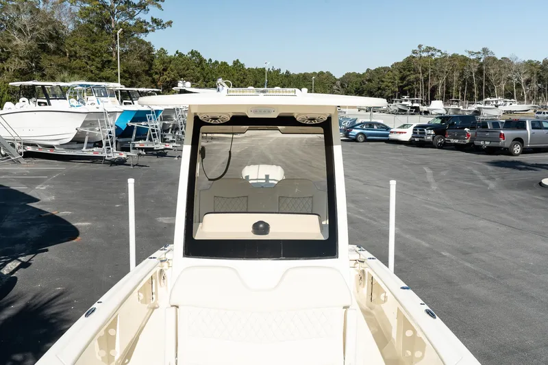  Yacht Photos Pics 2025 Scout 261 XSS boat in a parking lot with other boats and vehicles.