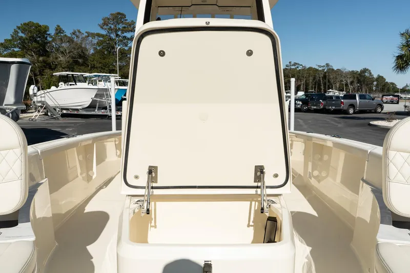  Yacht Photos Pics 2025 Scout 261 XSS boat with open storage compartment, parked outdoors.