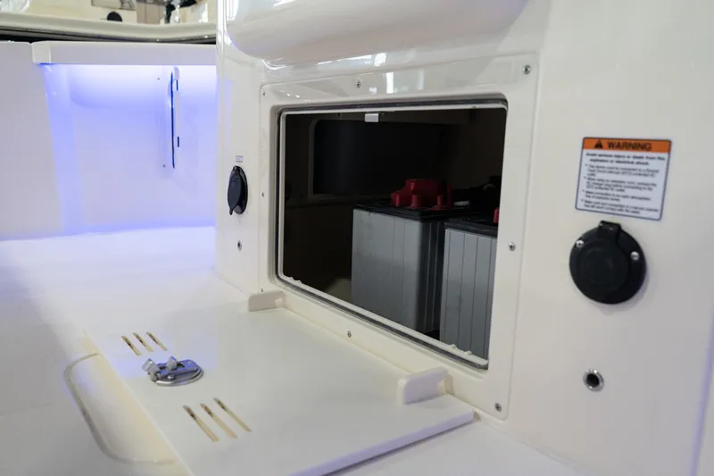  Yacht Photos Pics 2025 Scout 261 XSS boat storage compartment with battery and warning label.