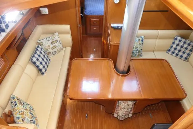 Peregrine Yacht Photos Pics Interior of 2002 Tayana 460 Vancouver Pilothouse with wooden table and cushioned seating.