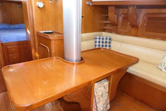 Peregrine Yacht Photos Pics 2002 Tayana 460 Vancouver Pilothouse interior with wooden dining area and cushioned seating.