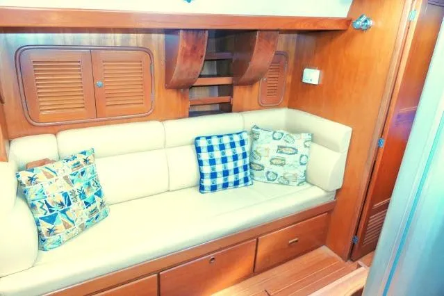 Peregrine Yacht Photos Pics Interior of 2002 Tayana 460 Vancouver Pilothouse with beige sofa and decorative pillows.