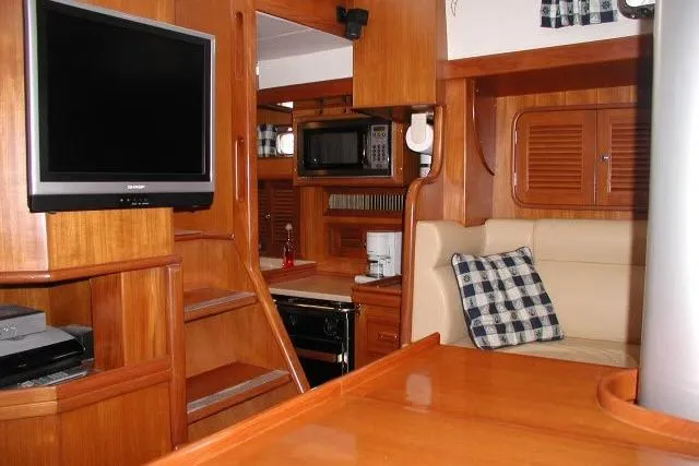 Peregrine Yacht Photos Pics Interior of 2002 Tayana 460 Vancouver Pilothouse with wood finish, TV, and cozy seating area.