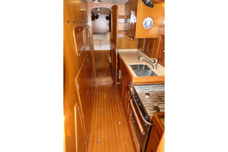 Peregrine Yacht Photos Pics 2002 Tayana 460 Vancouver Pilothouse interior with wood finish, kitchen, and sleeping area.