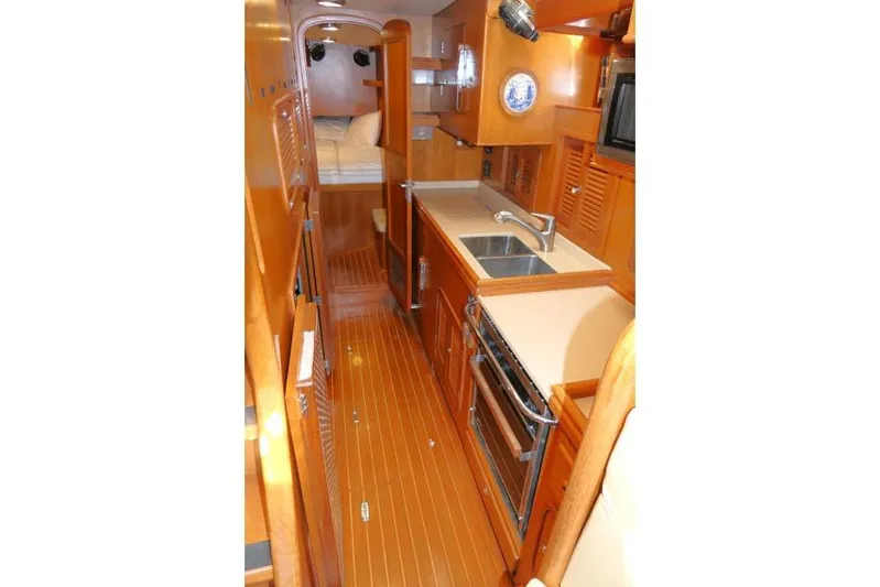 Peregrine Yacht Photos Pics Interior of 2002 Tayana 460 Vancouver Pilothouse, featuring a compact kitchen and cozy sleeping area.