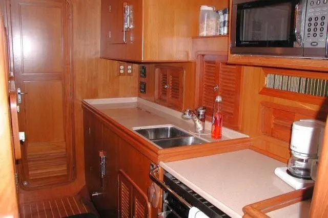 Peregrine Yacht Photos Pics 2002 Tayana 460 Vancouver Pilothouse kitchen with wooden cabinetry and modern appliances.