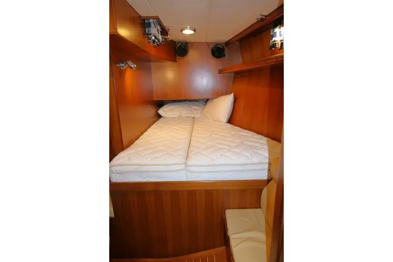 Peregrine Yacht Photos Pics Cozy cabin interior of 2002 Tayana 460 Vancouver Pilothouse with wooden finish and comfortable bedding.