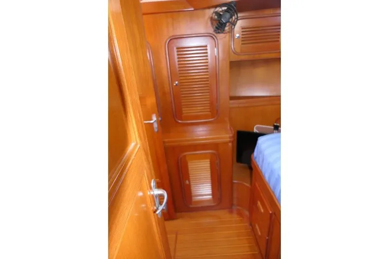 Peregrine Yacht Photos Pics Interior of 2002 Tayana 460 Vancouver Pilothouse with wooden cabinetry and blue bedding.