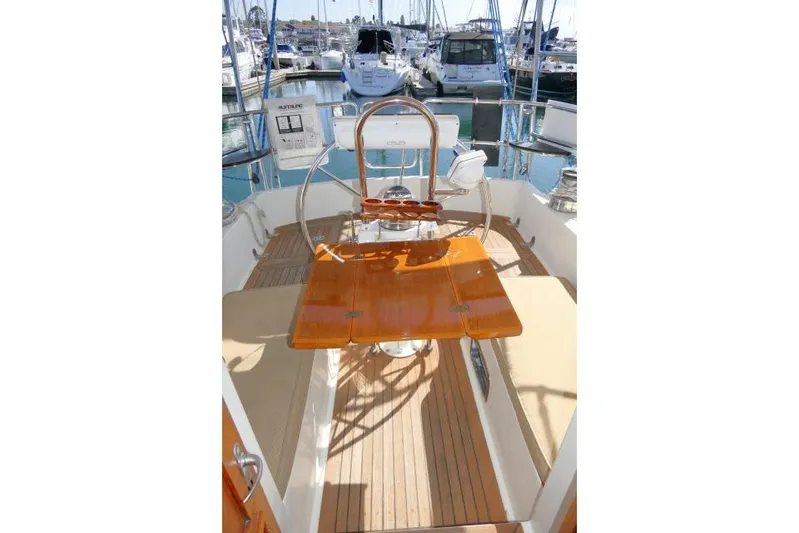 Peregrine Yacht Photos Pics Pilothouse of 2002 Tayana 460 Vancouver yacht with wooden table and steering wheel.