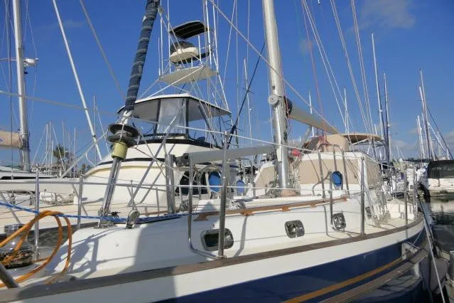 Peregrine Yacht Photos Pics 2002 Tayana 460 Vancouver Pilothouse sailboat docked in a marina under clear blue skies.