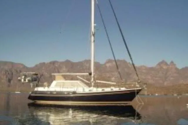 Peregrine Yacht Photos Pics 2002 Tayana 460 Vancouver Pilothouse yacht on calm water with mountainous backdrop.