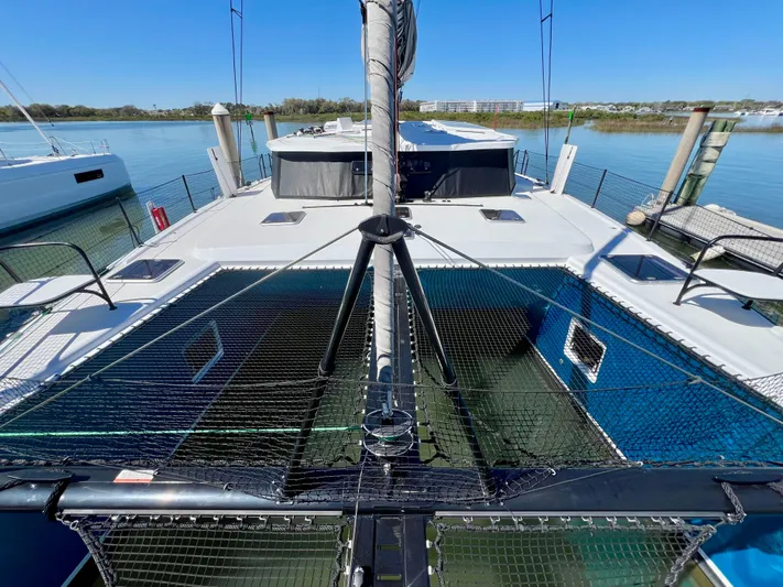 Silver Chain Yacht Photos Pics 2024 Balance 442 catamaran docked, showcasing spacious deck and netting, under clear blue sky.