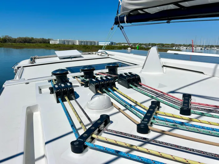 Silver Chain Yacht Photos Pics 2024 Balance 442 sailboat deck with colorful ropes and winches, docked by calm waters.