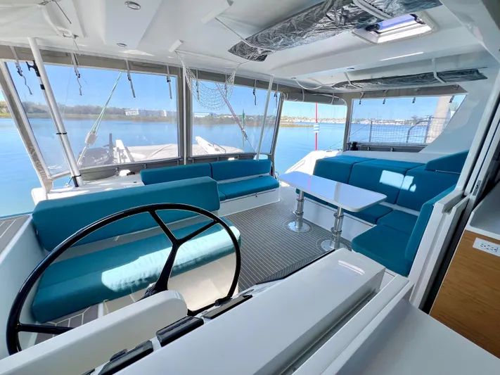 Silver Chain Yacht Photos Pics Luxurious 2024 Balance 442 yacht interior with blue seating and panoramic windows.