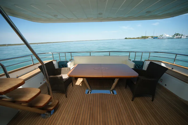  Yacht Photos Pics Luxury yacht deck with seating and table, VZ 68 model, 2009, overlooking serene waters.