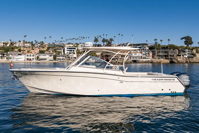  Yacht Photos Pics 2018 Grady-White Freedom 307 boat on calm water, coastal background with palm trees.