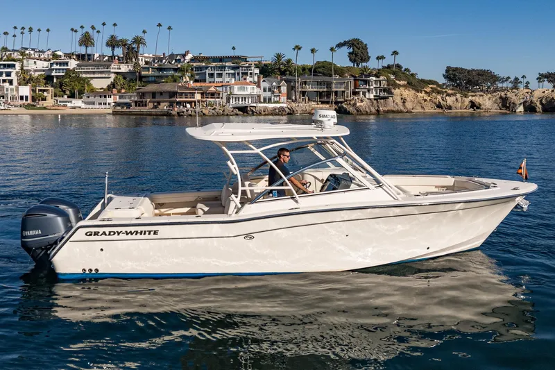  Yacht Photos Pics 2018 Grady-White Freedom 307 boat cruising near coastal homes and palm trees.