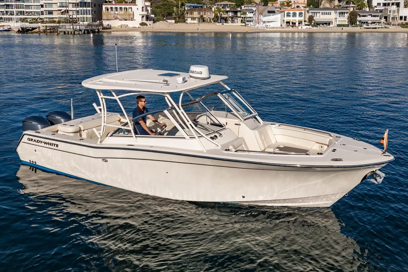  Yacht Photos Pics 2018 Grady-White Freedom 307 boat cruising on calm waters near a coastal town.