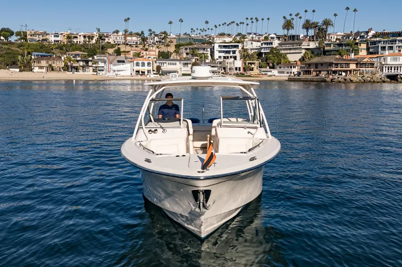  Yacht Photos Pics 2018 Grady-White Freedom 307 boat on calm water near coastal homes.
