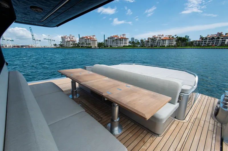 Ciao L Yacht Photos Pics Luxurious SACS Rebel 55 yacht deck with seating, overlooking waterfront buildings, 2022 model.