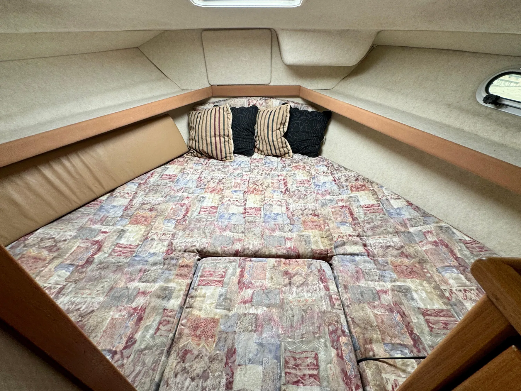 Cozy cabin interior of 1998 Bayliner 3388 Command Bridge Motoryacht with patterned bedding.