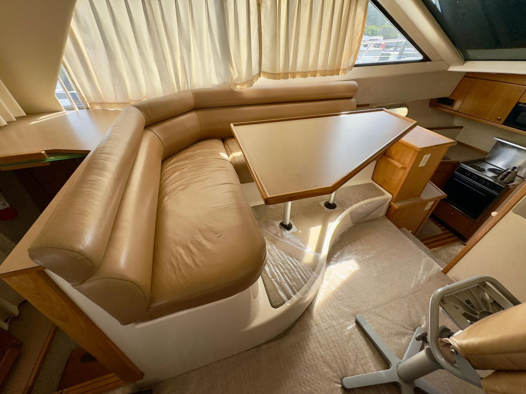 Interior of 1998 Bayliner 3388 Command Bridge Motoryacht with dining area and kitchenette.