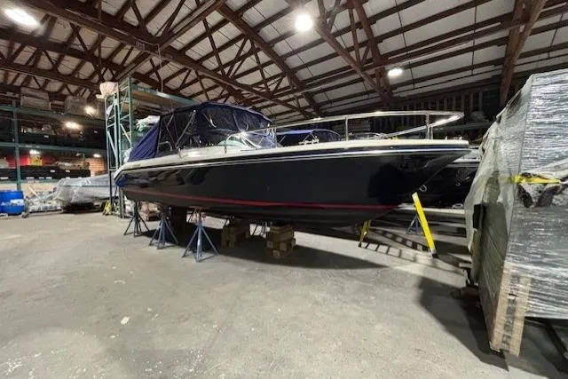 1998 Craig Craft Launch boat in storage, elevated on stands in a warehouse.