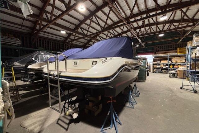 1998 Craig Craft Launch boat in storage, covered and elevated on stands.
