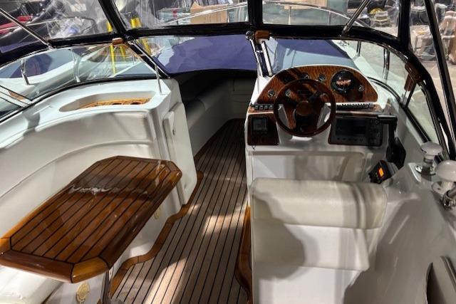 Interior of a 1998 Craig Craft Launch boat with wooden accents and steering wheel.