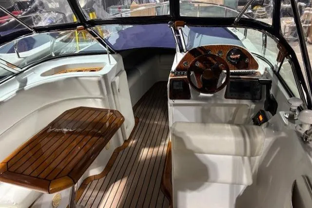 Interior of a 1998 Craig Craft Launch boat with wooden accents and steering wheel.