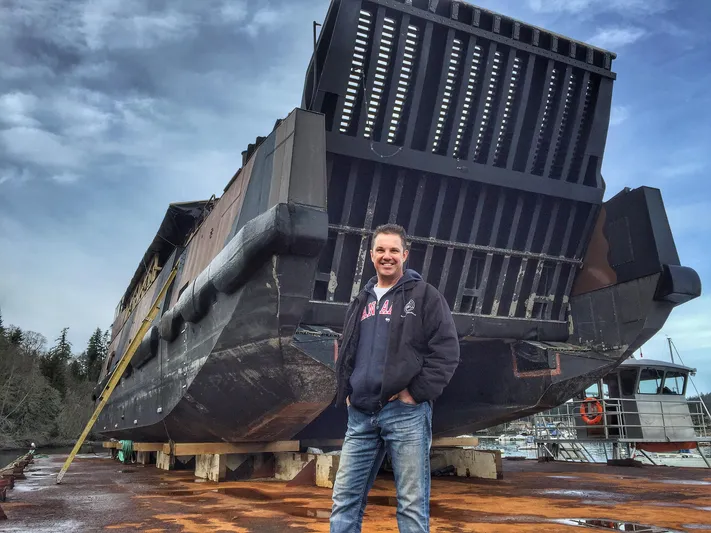 T1 Yacht Photos Pics Man standing in front of a 2009 Custom Aluminum Landing Craft on a dock.